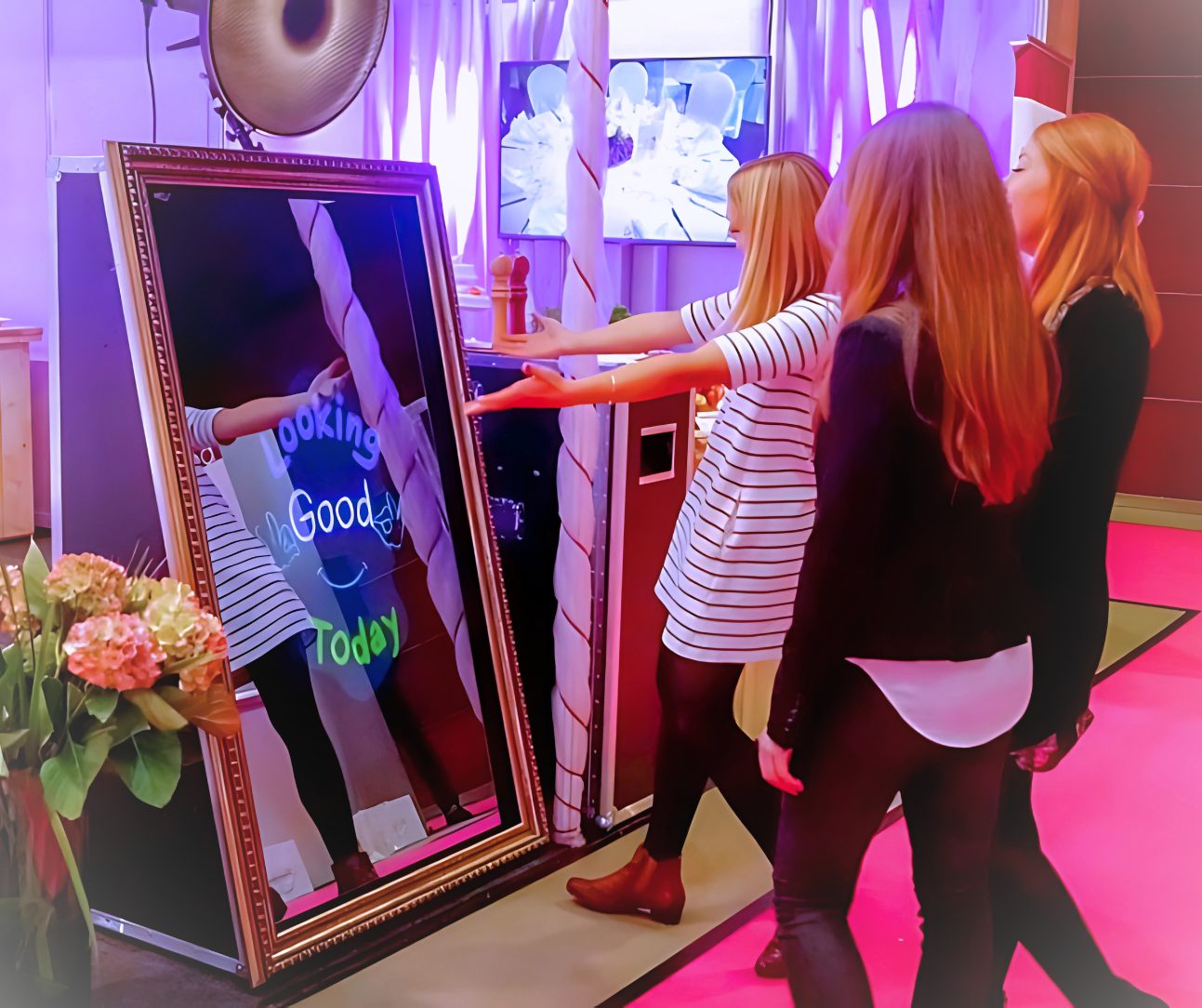 Guests having fun in front of the rectangle mirror photobooth